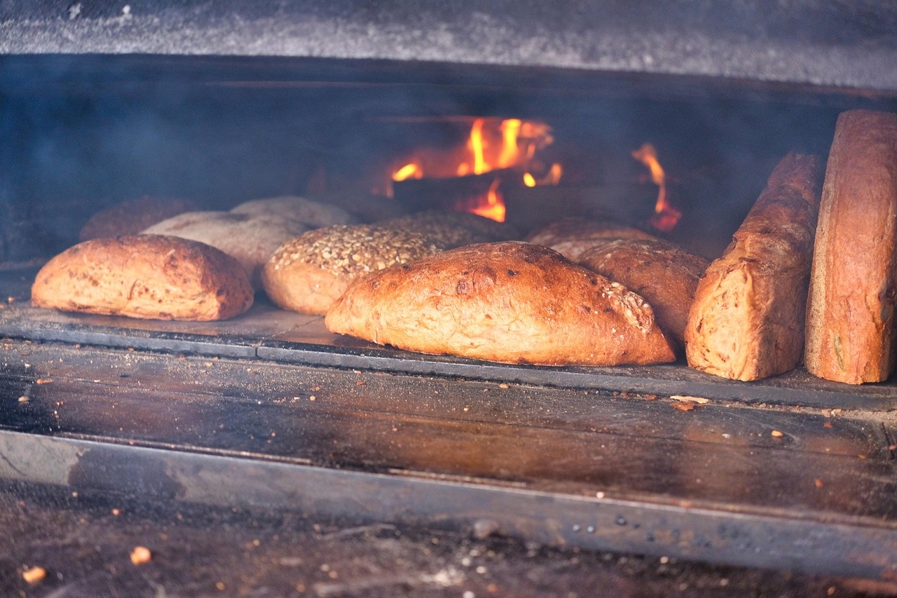 Pani artigianali che cuociono in un forno a legna con fiamma viva