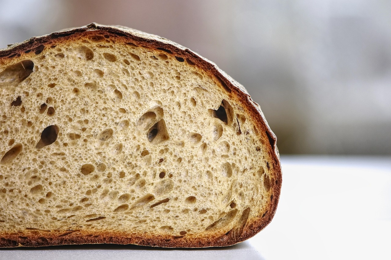 Sezione di pane a mollica aperta, con alveoli irregolari e crosta tostata