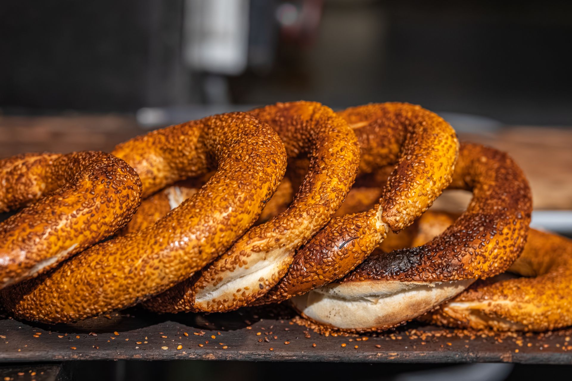 Ciambelle di pane al sesamo appoggiate su tavola scura